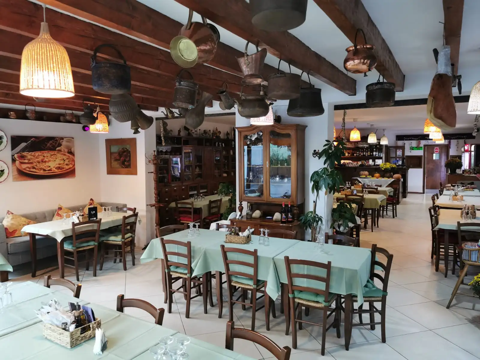 Sala restaurantului Trattoria Al Gallo, cu mese pregătite pentru oaspeți